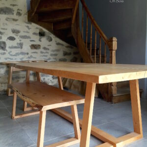 Grande table en bois massif sur mesure. Pieds triangulaires en bois. Avec son banc assorti en bois; travail artisanal mobilier en bois sur mesure.